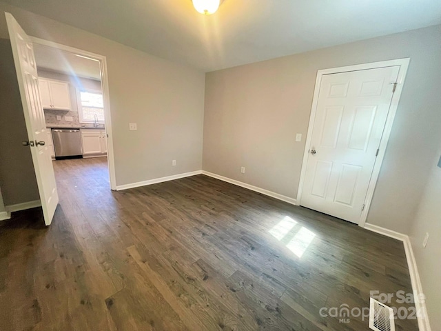 empty room featuring sink and dark hardwood / wood-style floors