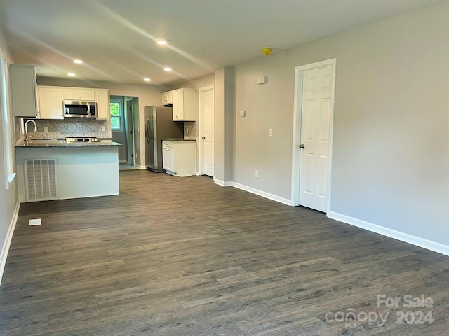 kitchen featuring white cabinetry, sink, dark wood-type flooring, kitchen peninsula, and appliances with stainless steel finishes