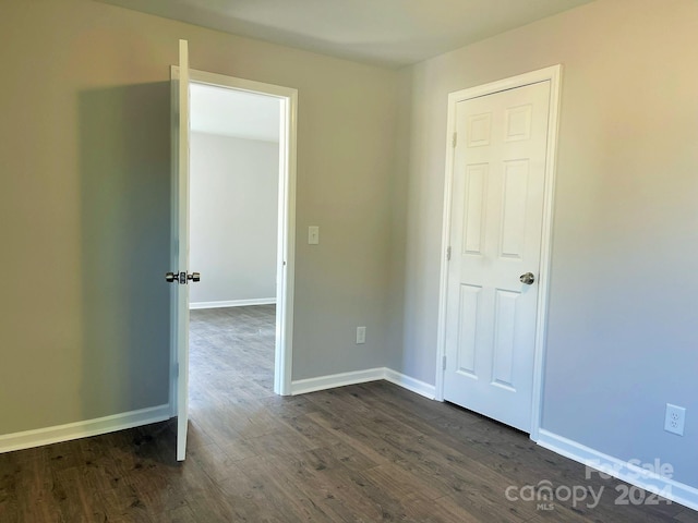 spare room featuring dark wood-type flooring