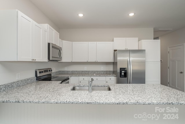 kitchen featuring white cabinetry, appliances with stainless steel finishes, and light stone counters