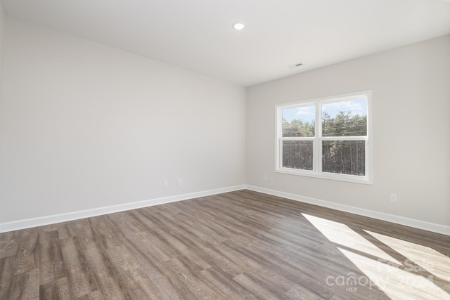 unfurnished room with wood-type flooring