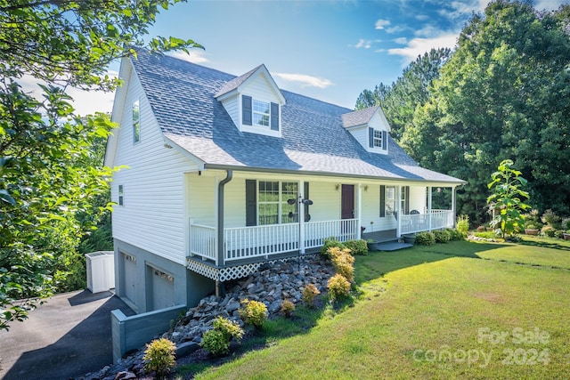 cape cod home with a front yard, a garage, and covered porch