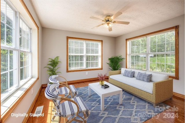 living room featuring a textured ceiling, dark hardwood / wood-style flooring, and ceiling fan