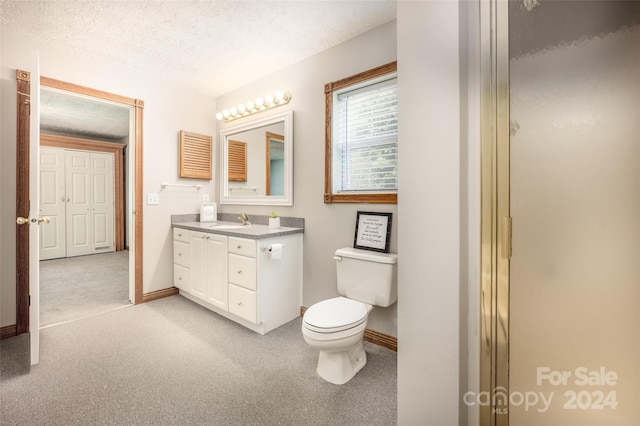 bathroom featuring toilet, a textured ceiling, walk in shower, and vanity