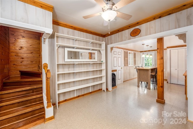 interior space with wood walls, ceiling fan, a breakfast bar, and wine cooler