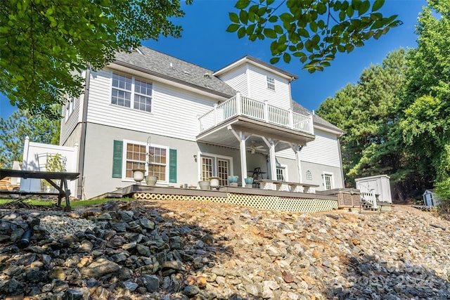 rear view of property featuring a balcony, a storage unit, ceiling fan, and a wooden deck