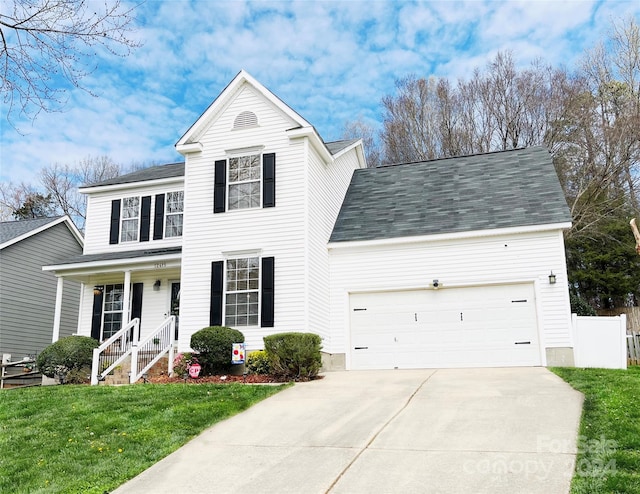 view of front of property featuring a garage, a front lawn, and a porch