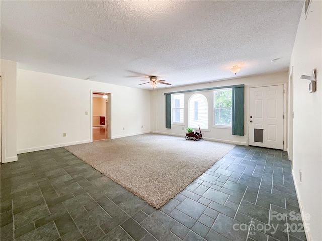 interior space with ceiling fan and a textured ceiling