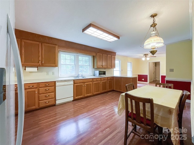 kitchen with decorative light fixtures, dishwasher, ceiling fan, light wood-type flooring, and kitchen peninsula