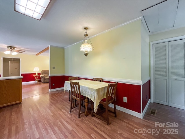 dining area with hardwood / wood-style floors, ornamental molding, and ceiling fan