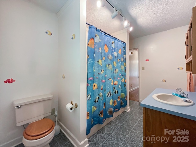 bathroom with a textured ceiling, a shower with shower curtain, vanity, and toilet