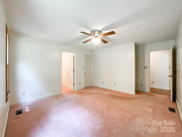 unfurnished bedroom with ceiling fan, light colored carpet, and a textured ceiling