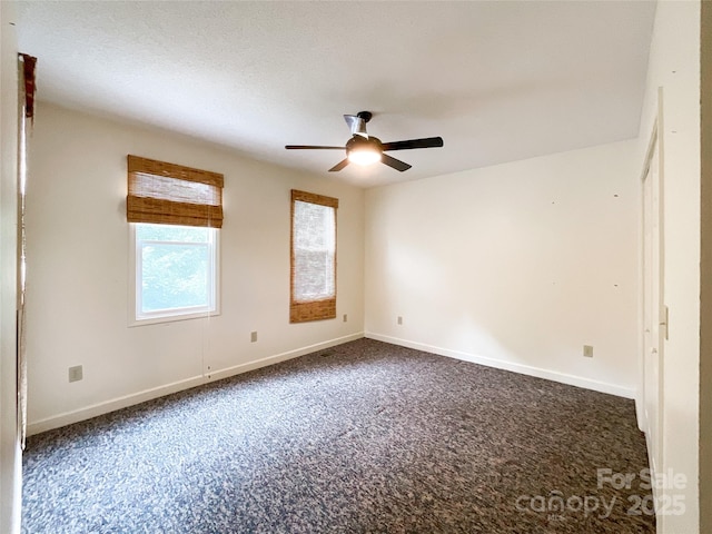 unfurnished room featuring ceiling fan and dark colored carpet