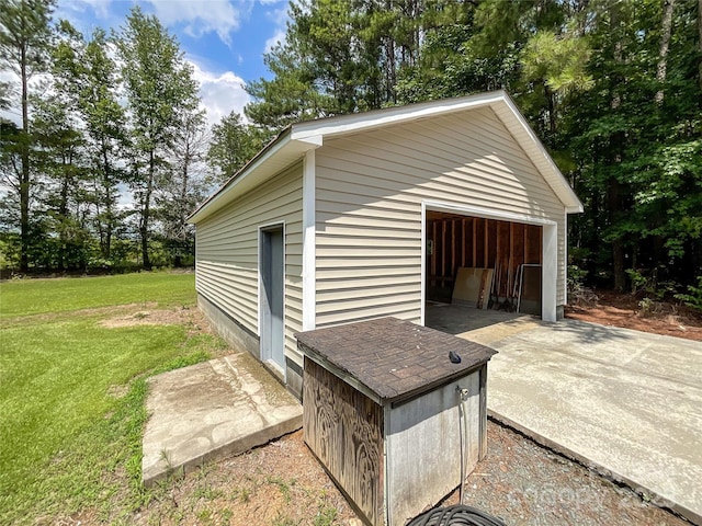 view of outdoor structure featuring a lawn and a garage