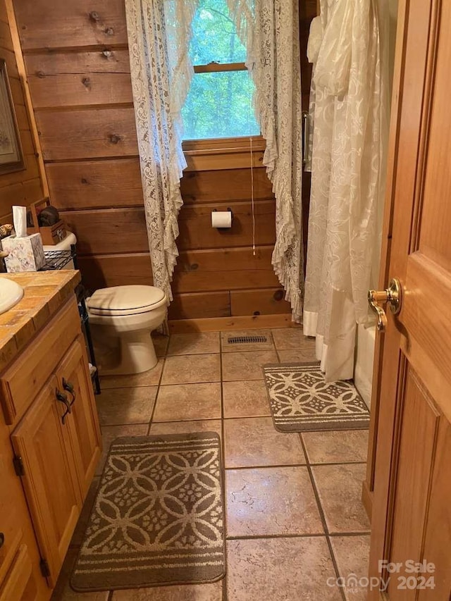 bathroom featuring tile patterned flooring, toilet, and vanity