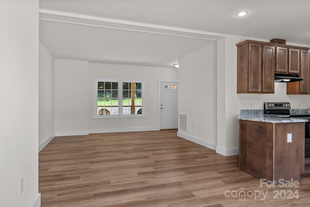 kitchen with electric range, light stone counters, and light hardwood / wood-style floors