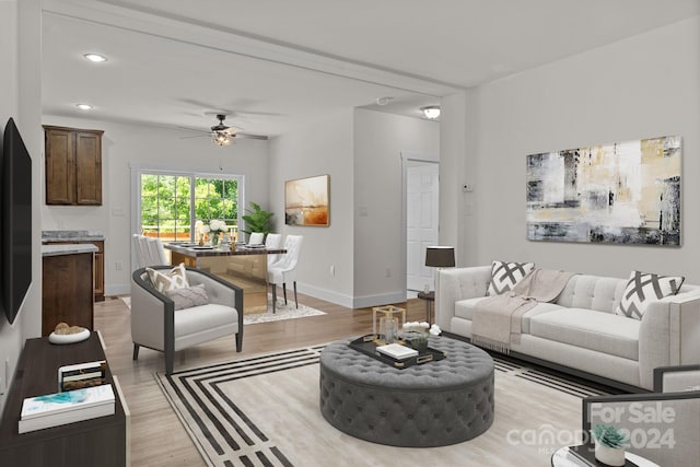 living room with ceiling fan and light hardwood / wood-style flooring