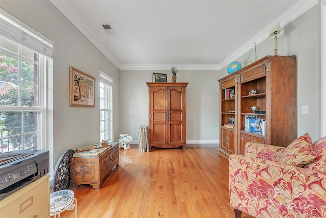 sitting room featuring ornamental molding and light wood-type flooring