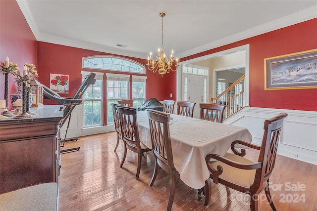 dining room with a chandelier, light hardwood / wood-style flooring, and crown molding