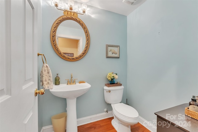 bathroom with hardwood / wood-style flooring and toilet