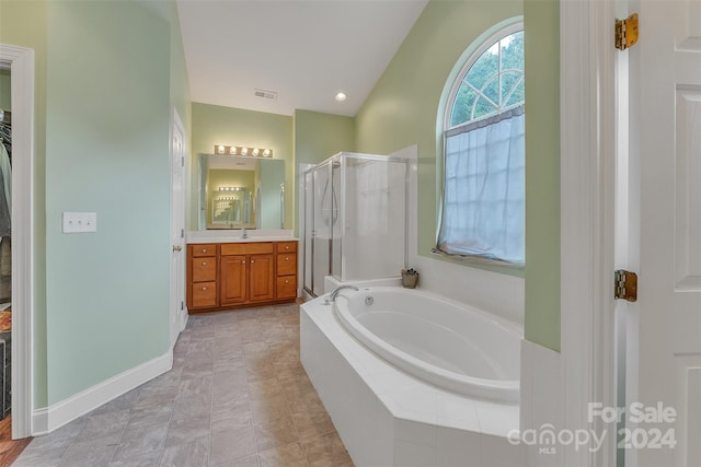 bathroom featuring tile patterned floors, vanity, plus walk in shower, and vaulted ceiling