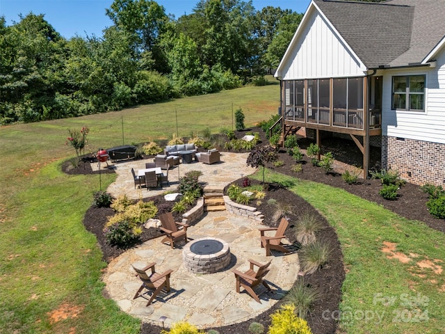 view of yard featuring an outdoor living space with a fire pit, a patio area, and a sunroom