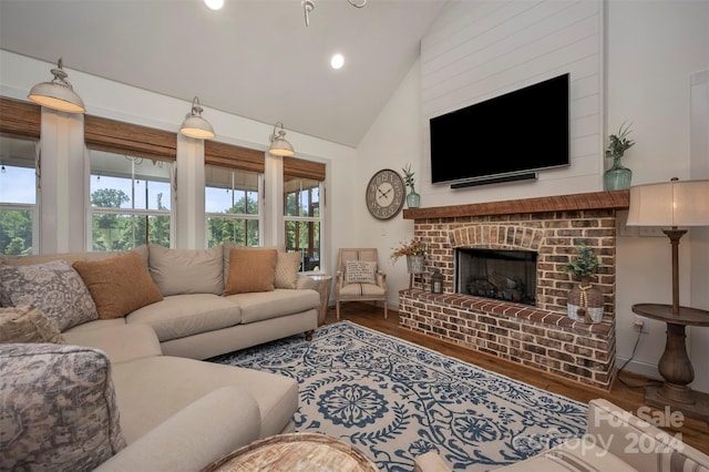 living room with high vaulted ceiling, a fireplace, and hardwood / wood-style floors