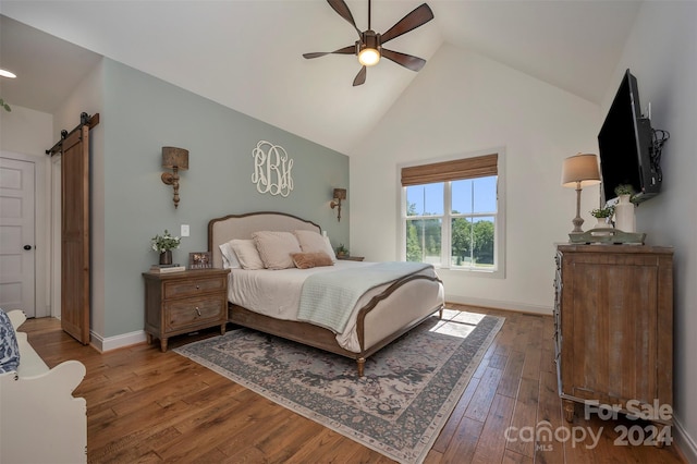 bedroom featuring ceiling fan, lofted ceiling, a barn door, and hardwood / wood-style floors