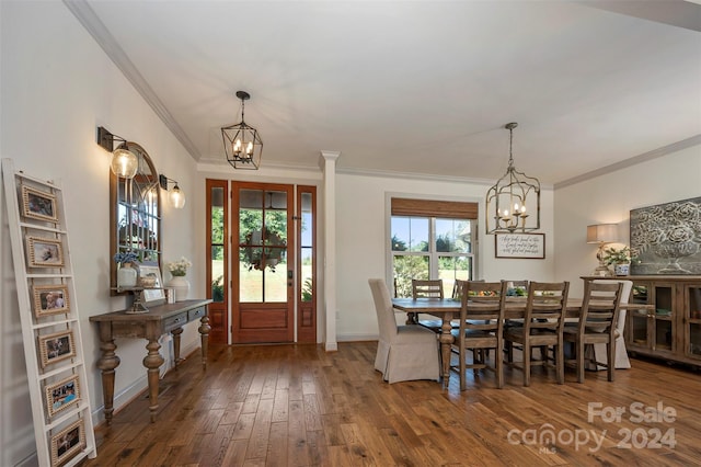 dining room with dark wood-type flooring, an inviting chandelier, and crown molding