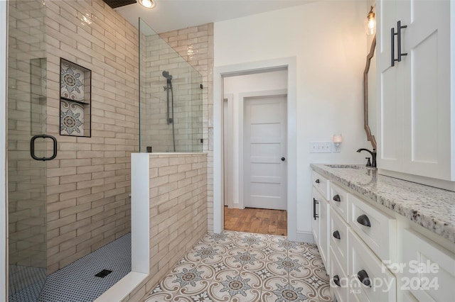 bathroom with walk in shower, tile patterned floors, and vanity