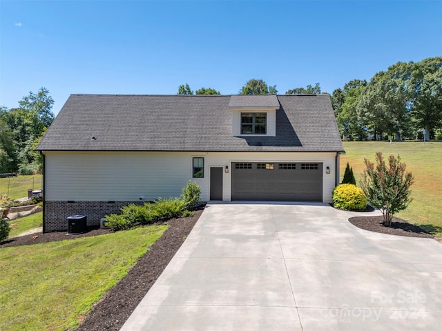 view of front facade with a front lawn, a garage, and cooling unit