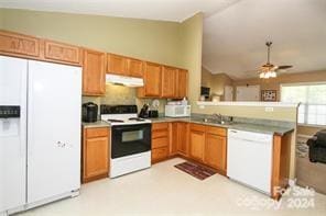 kitchen featuring sink, white appliances, kitchen peninsula, and lofted ceiling