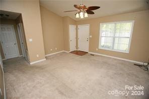 empty room featuring ceiling fan and light colored carpet