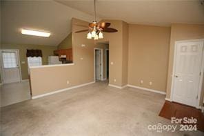 unfurnished living room with ceiling fan, light colored carpet, and lofted ceiling