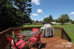 wooden terrace featuring a lawn and grilling area