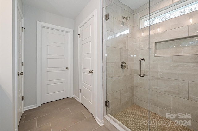 bathroom with tile patterned floors and a shower with shower door