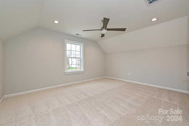 additional living space with light colored carpet, ceiling fan, and lofted ceiling