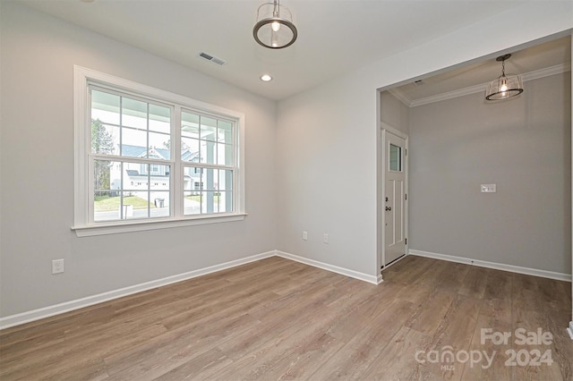 spare room with crown molding and light hardwood / wood-style flooring