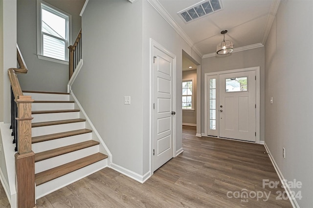 foyer featuring wood-type flooring and crown molding