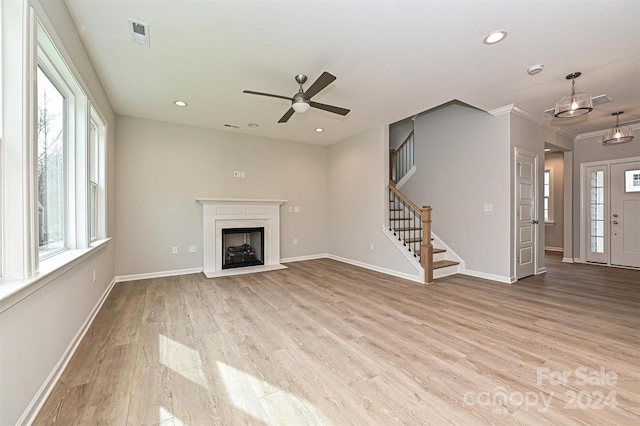 unfurnished living room with crown molding, ceiling fan, plenty of natural light, and light hardwood / wood-style floors