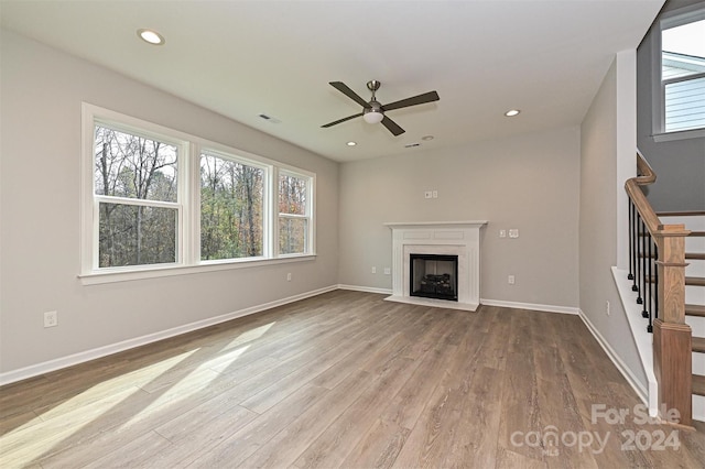 unfurnished living room featuring ceiling fan and light hardwood / wood-style flooring