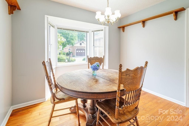 dining room with light hardwood / wood-style flooring and a chandelier