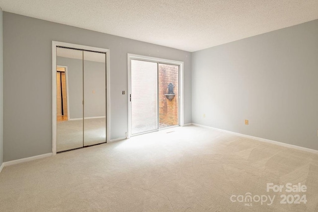 unfurnished bedroom featuring a closet, carpet floors, and a textured ceiling