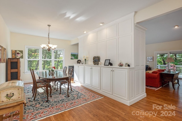 dining area featuring light hardwood / wood-style floors and an inviting chandelier