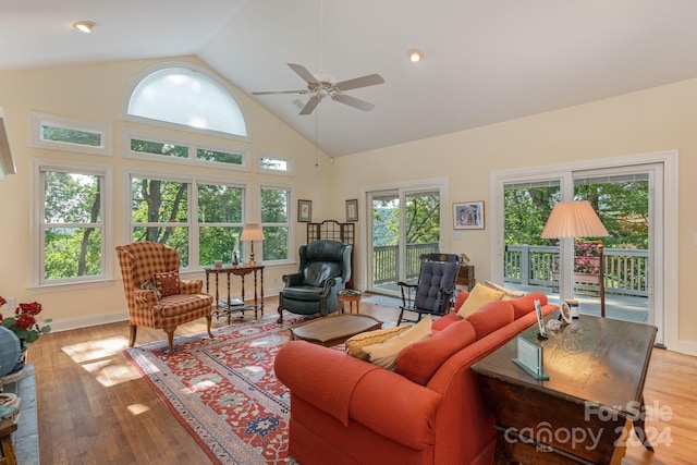 living room with ceiling fan, high vaulted ceiling, and light hardwood / wood-style floors