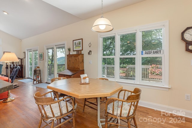 dining area with hardwood / wood-style floors and vaulted ceiling