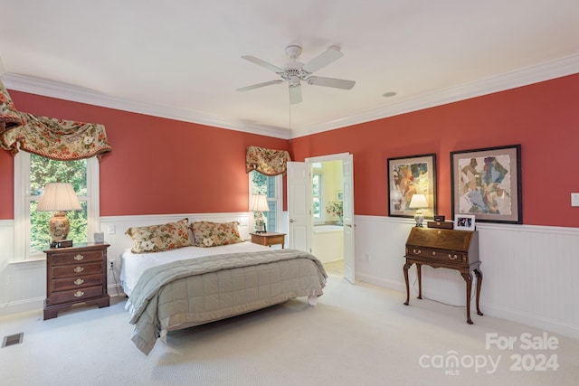 carpeted bedroom with ceiling fan, ornamental molding, and ensuite bath