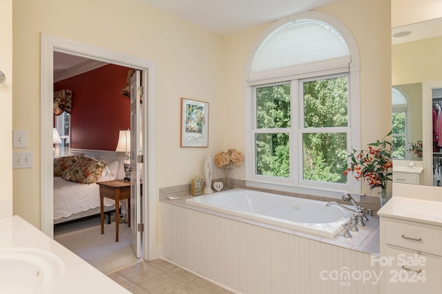 bathroom with tile patterned floors, vanity, and tiled bath