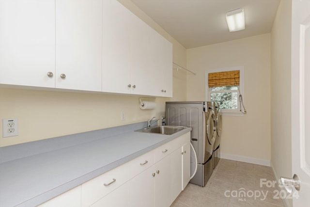 laundry area with washer and dryer, cabinets, light tile patterned floors, and sink