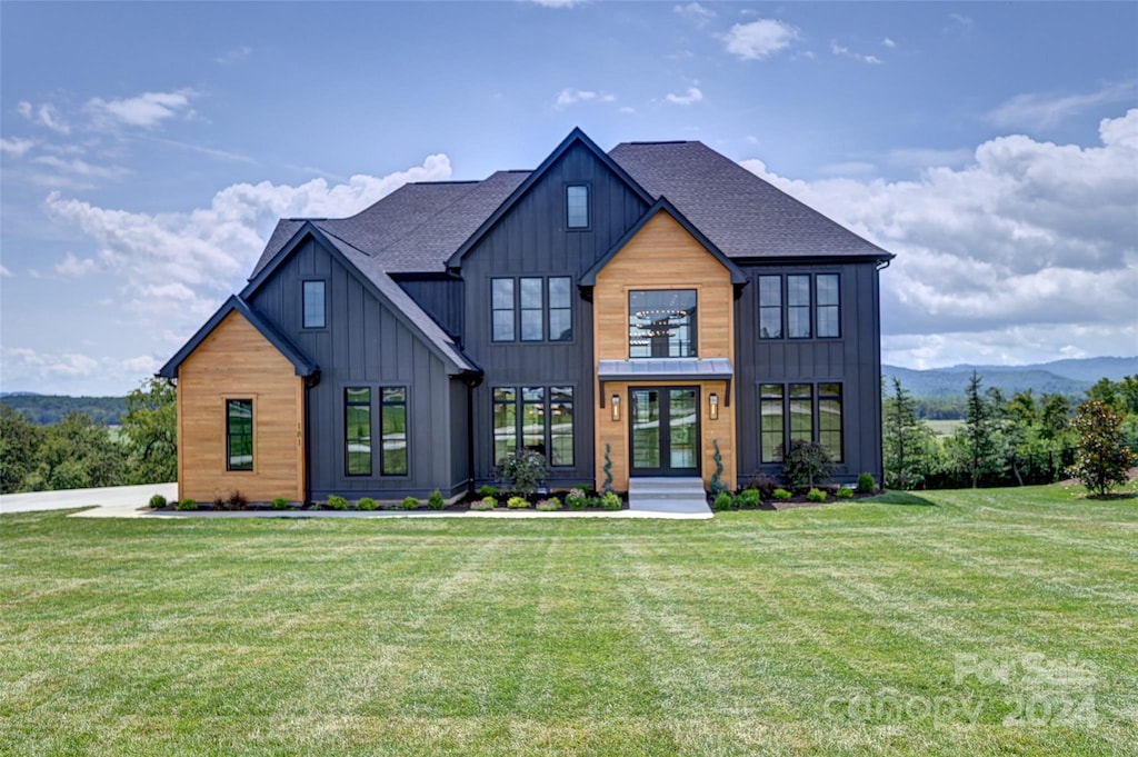 view of front facade with a front yard and french doors